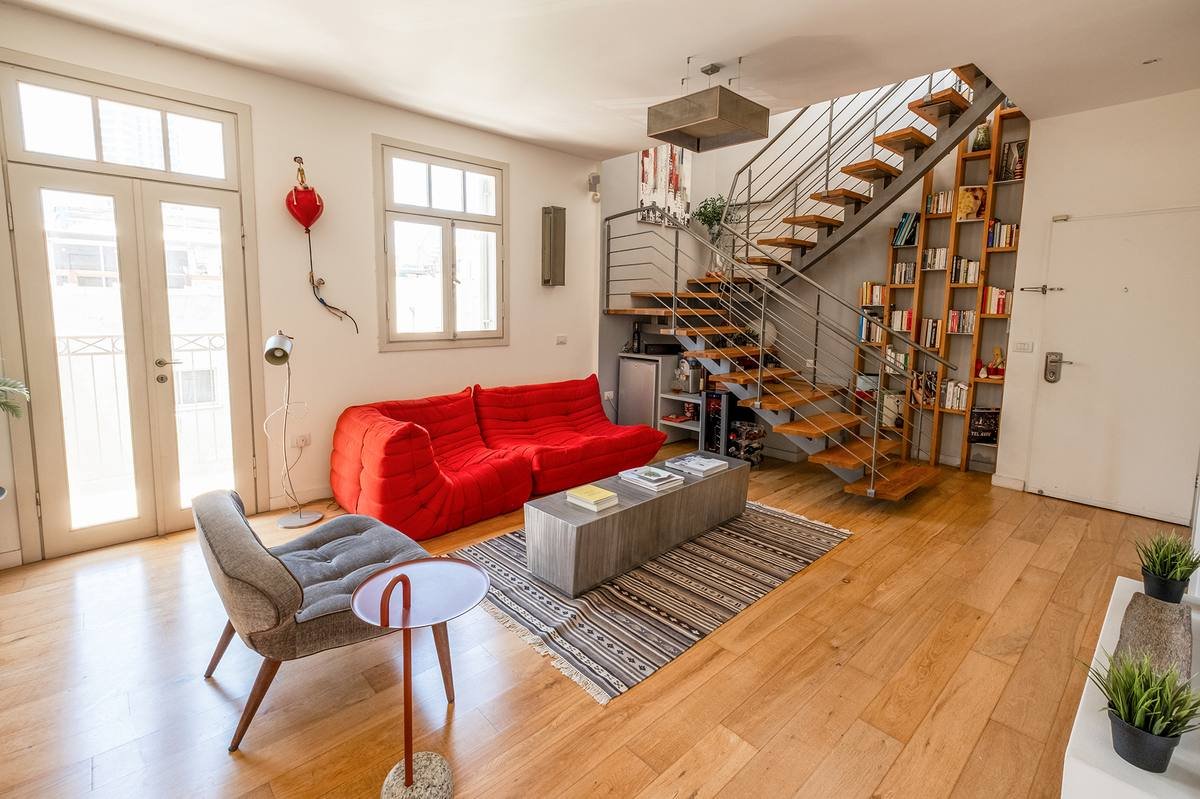Private living room on Floor 3 of the Shefer 19 duplex penthouse, with staircase rising to Floor 4